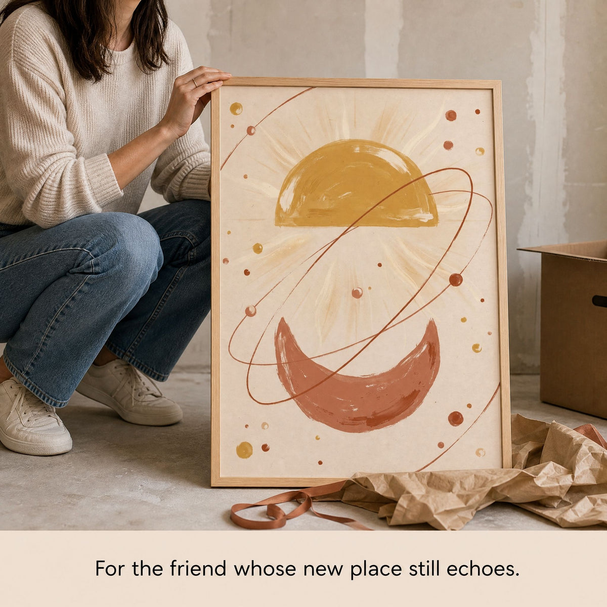 A housewarming gift being unwrapped: the framed boho sun and moon print resting on kraft paper.