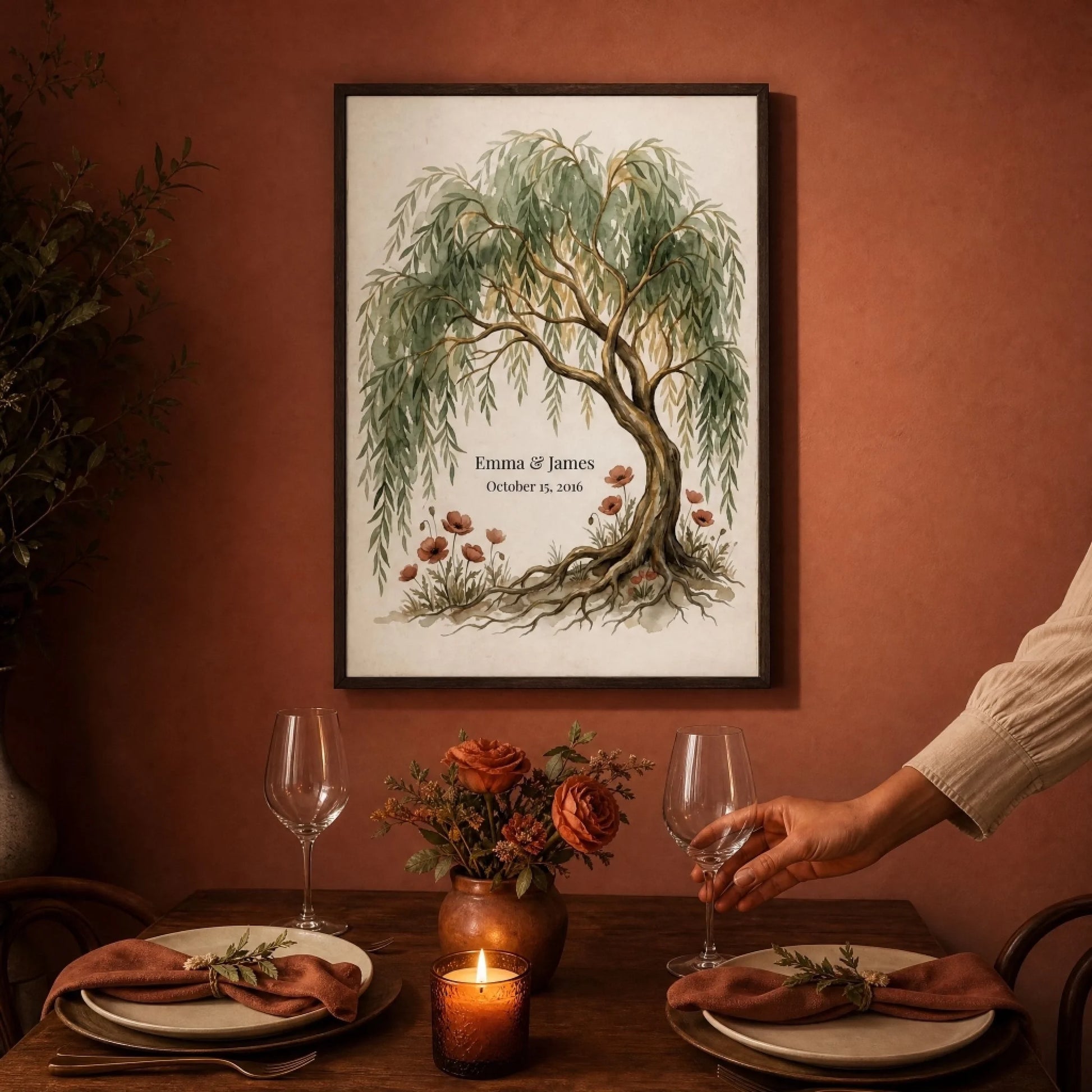 Framed willow tree anniversary print on a warm wall above a candlelit dinner table set for two