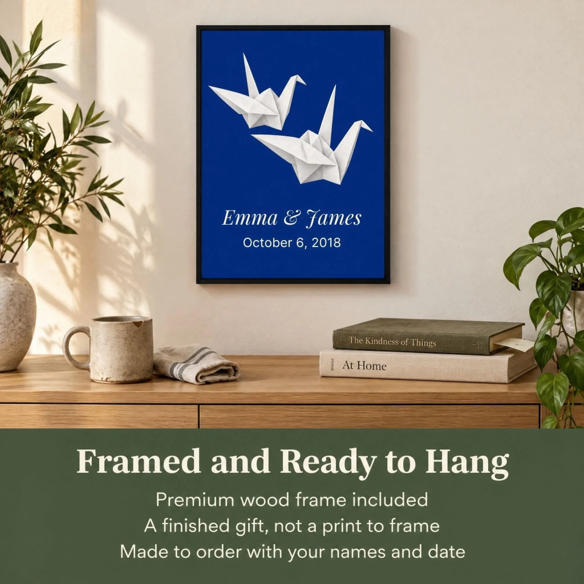 Personalized paper cranes anniversary print framed in black, hung above a console with the ready to hang promise