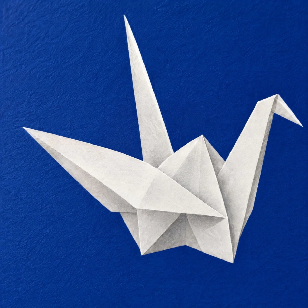 Close up of the paper cranes print showing matte paper grain under the flat ink blue ink
