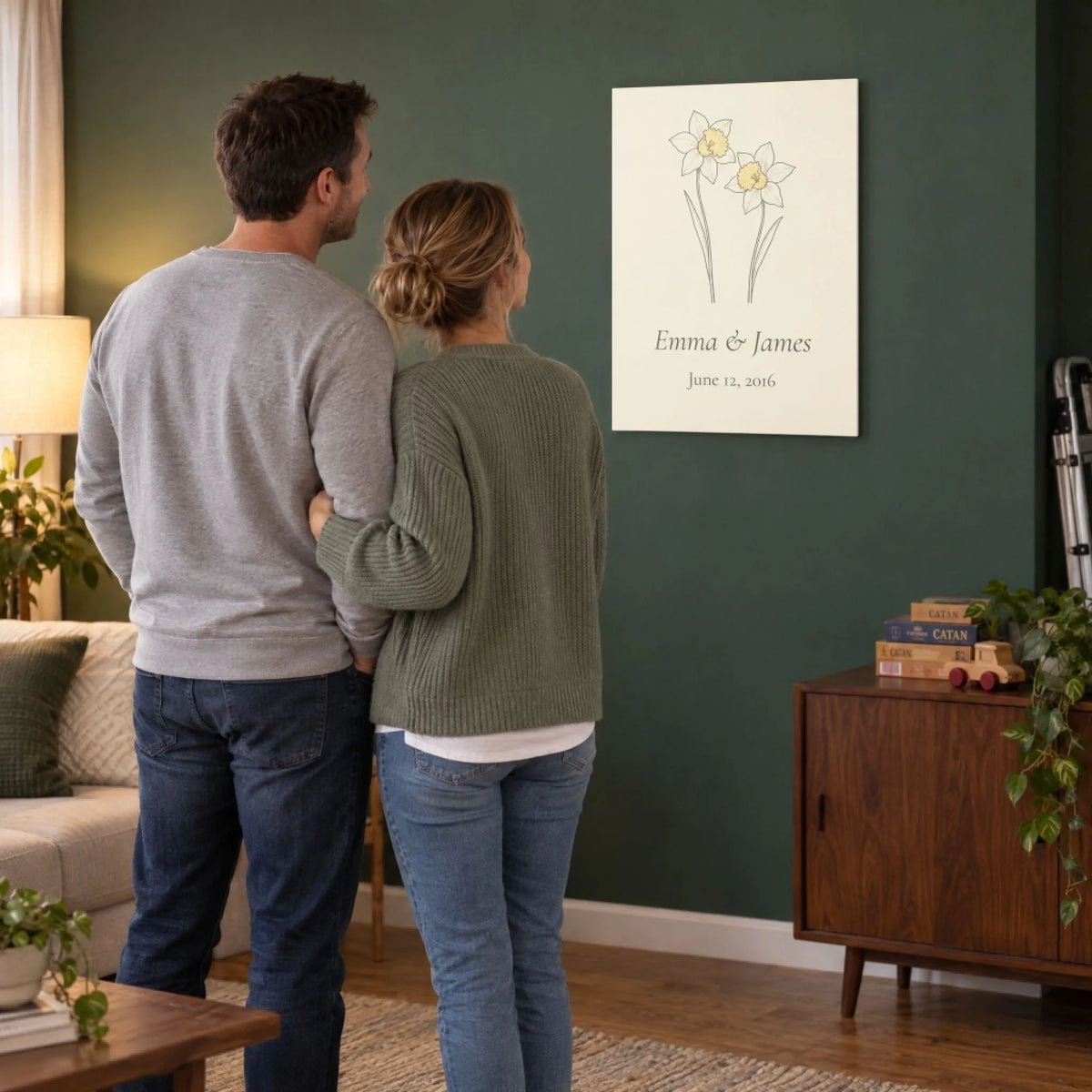 Husband and wife looking at the daffodil metal print they hung for their 10th anniversary