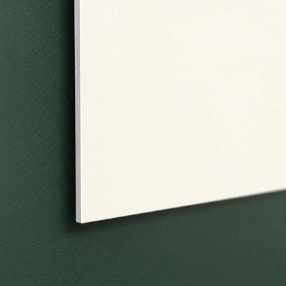 Side view of the thin aluminum panel sitting just off a green wall with no visible hardware