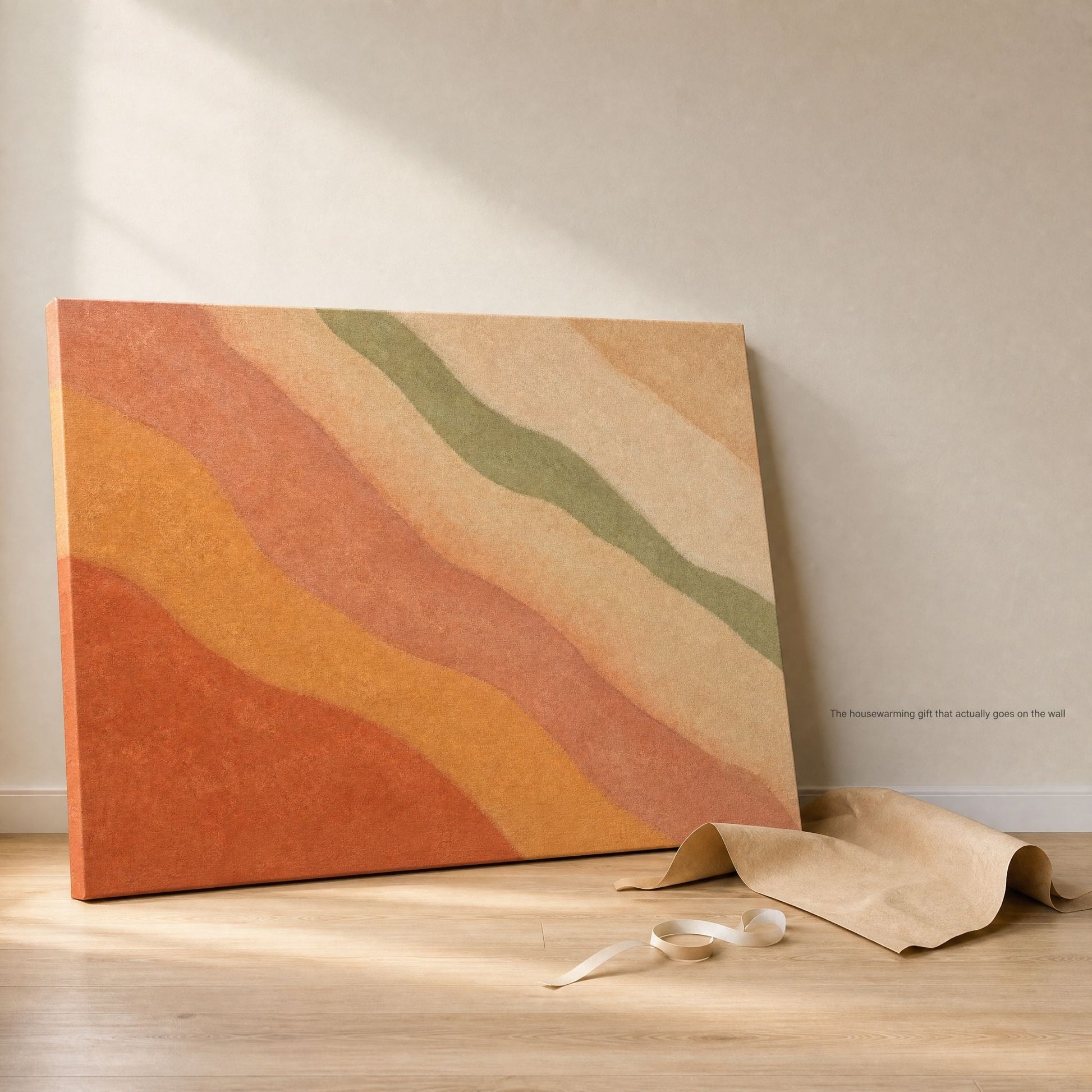 Canvas leaning against a wall on a wood floor beside its kraft paper packaging