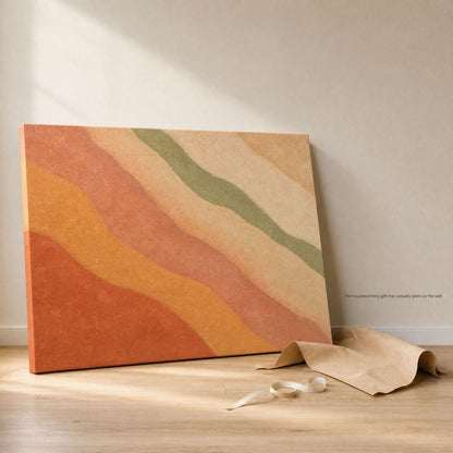 Canvas leaning against a wall on a wood floor beside its kraft paper packaging