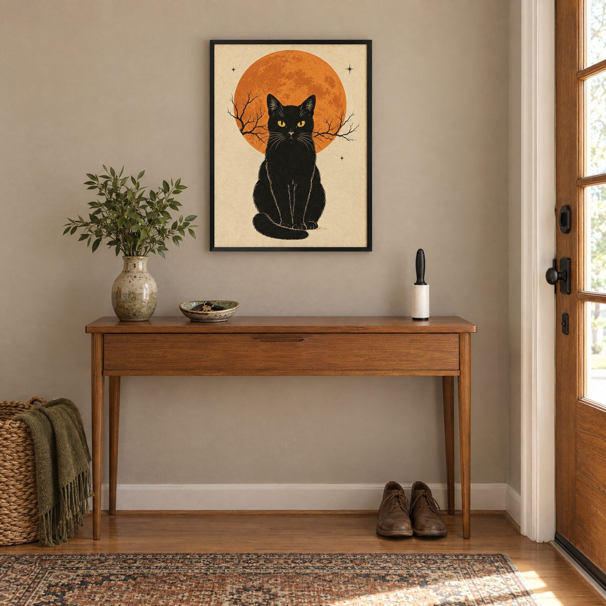 Framed black cat print above an entryway console beside the front door, sized for a hallway wall
