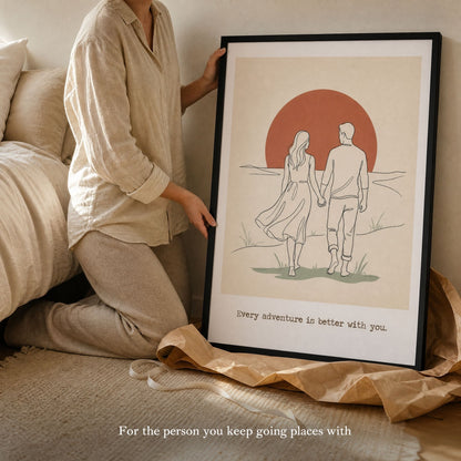A large framed couples print held on a bed with kraft paper below it, just unwrapped as a gift.