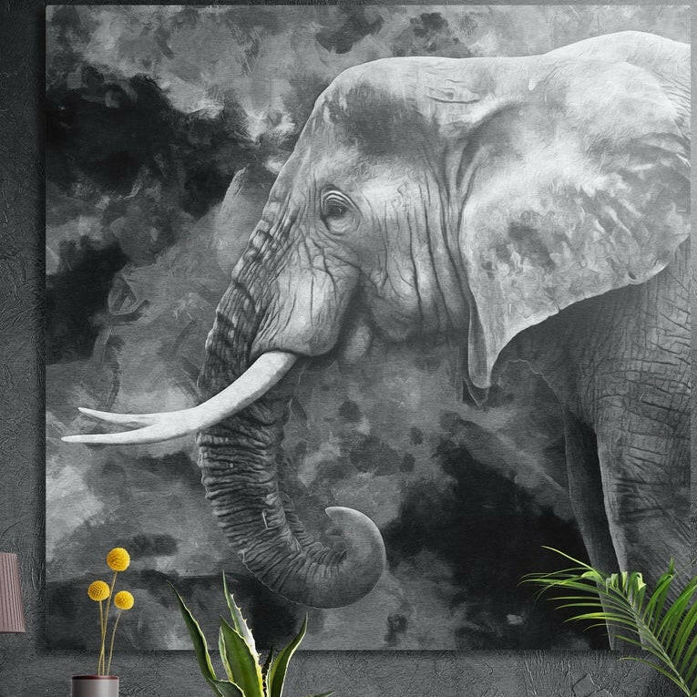 Black and white elephant with curved tusks in smoky clouds, brushed aluminum wall art on a dark wall behind plants