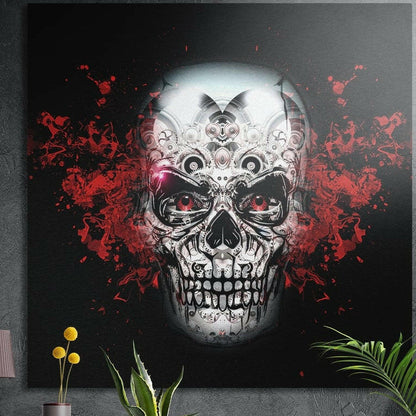 Ornate silver sugar skull with red eyes and red splatter, brushed aluminum wall art on a dark wall behind plants