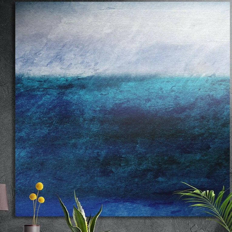Textured deep blue sea meeting a pale misty sky in a soft abstract seascape, brushed aluminum wall art above potted plants