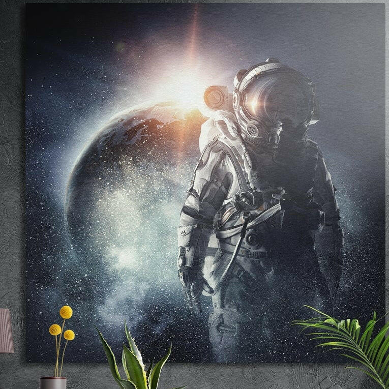 Astronaut in a white suit beside a dark planet with a bright sun flare, brushed aluminum wall art above plants
