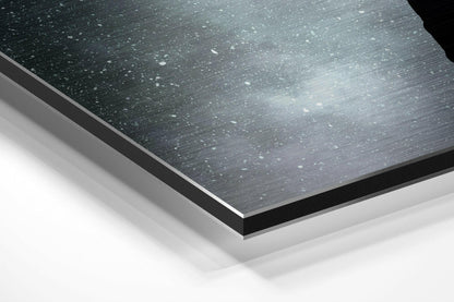 Man lifted by balloons across the moon brushed aluminum panel corner close-up showing the brushed metal grain