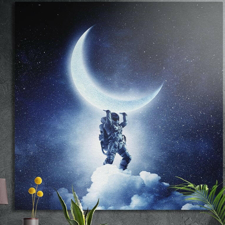 Astronaut on a cloud lifting a glowing crescent moon in a starry sky, brushed aluminum wall art behind plants
