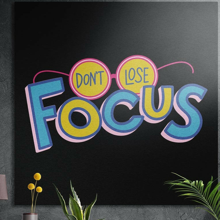 Retro blue and yellow motivational lettering with pink glasses on black, brushed aluminum wall art behind plants