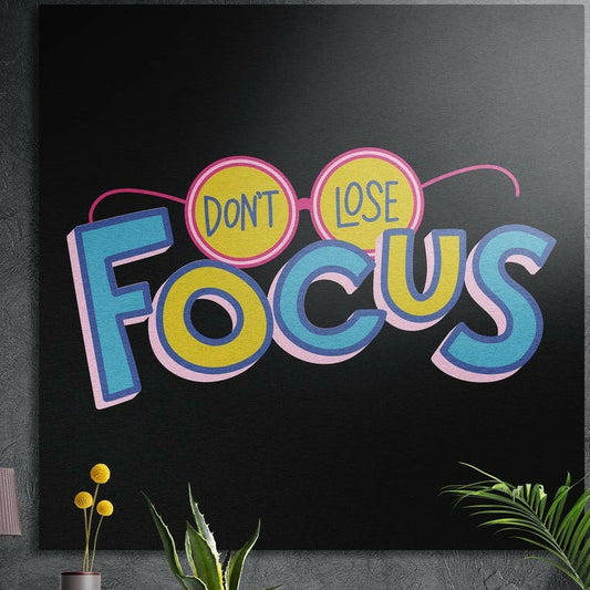 Retro blue and yellow motivational lettering with pink glasses on black, brushed aluminum wall art behind plants