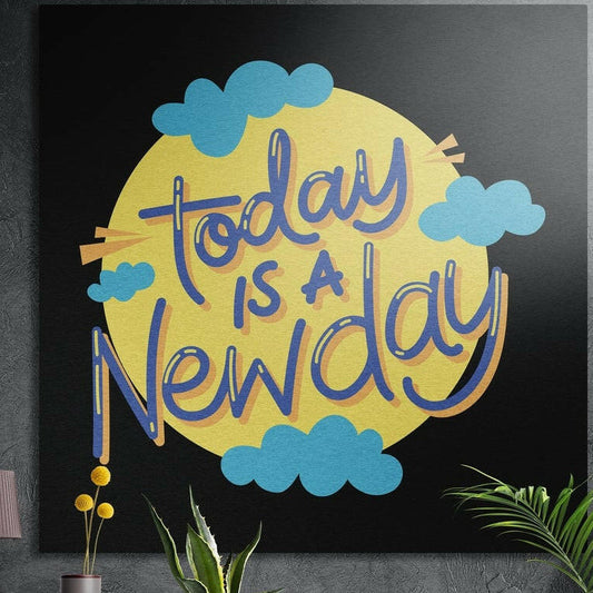 Today is a new day lettering on a yellow sun with blue clouds, brushed aluminum wall art on a dark wall behind plants