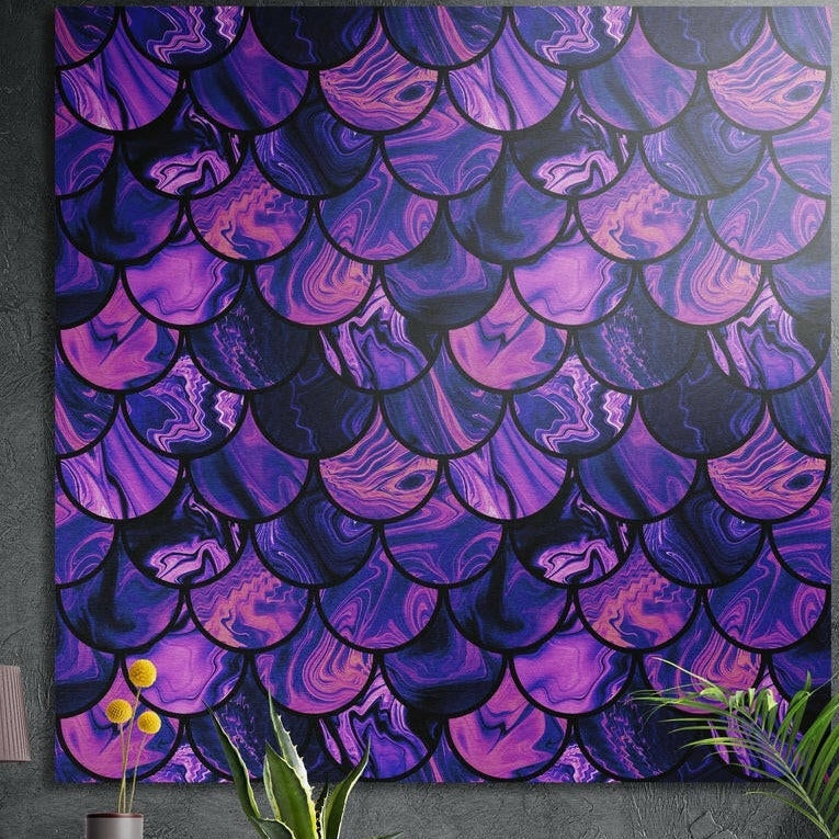 Purple and pink marbled scale pattern brushed aluminum wall art on a dark textured wall behind yellow flowers and plants