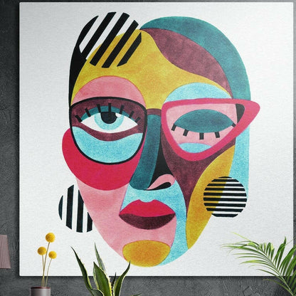 Pink cat eye glasses abstract face brushed aluminum wall art hung on a dark textured wall above potted plants