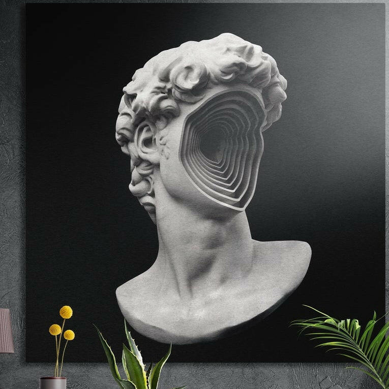 Gray statue bust with spiral void face brushed aluminum wall art on a gray wall above yellow flowers and plants