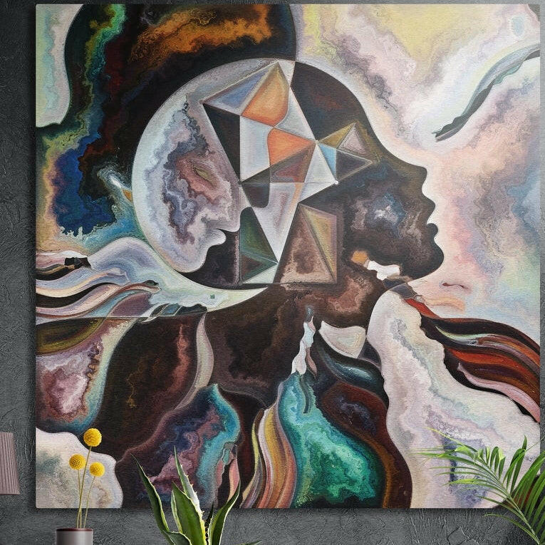 Two profile faces with a geometric star brushed aluminum wall art on a dark wall above yellow flowers and plants
