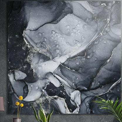 Black and silver ink marble brushed aluminum wall art on a dark wall above yellow flowers and plants