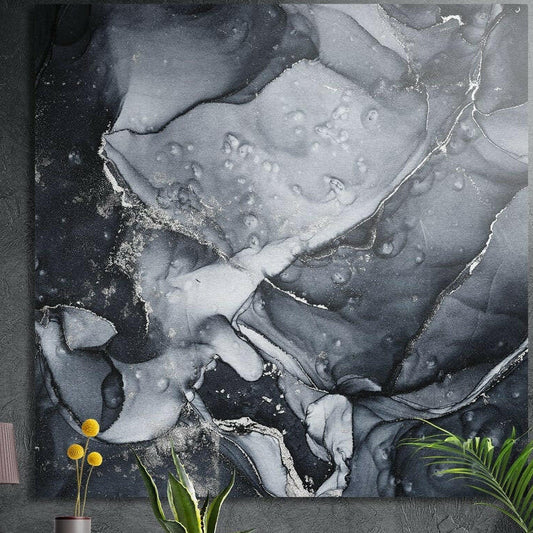 Black and silver ink marble brushed aluminum wall art on a dark wall above yellow flowers and plants