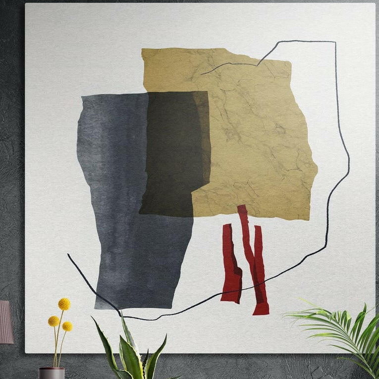 Torn ochre and slate paper shapes with red strips and a black line on white, square brushed aluminum wall art on a dark wall