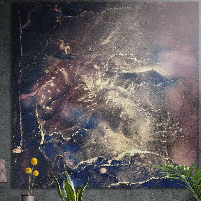 Navy, plum and gold marble artwork as brushed aluminum wall art on a dark concrete wall behind yellow flowers and plants