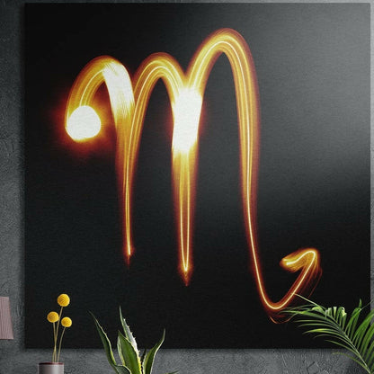 Scorpio zodiac sign in amber light brushed aluminum wall art on a gray concrete wall above plants