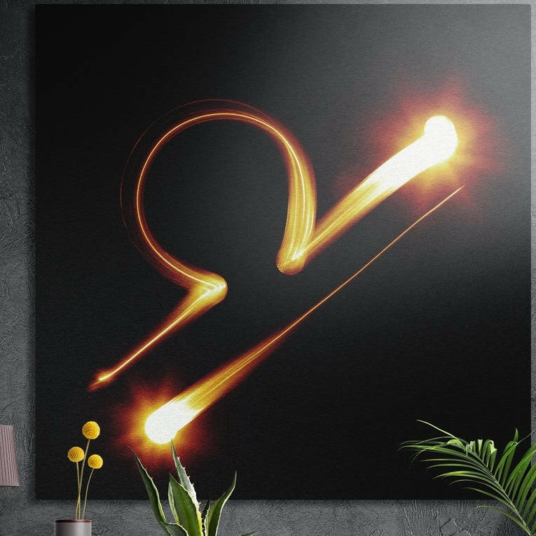 Libra zodiac sign in blazing orange light brushed aluminum wall art on a gray concrete wall above plants