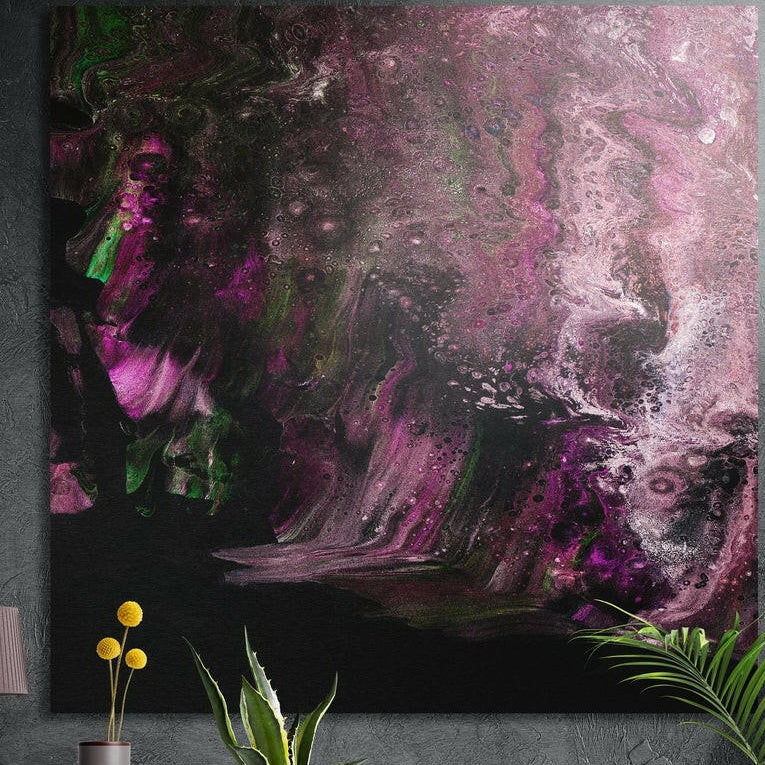 Smoky mauve and pink abstract brushed aluminum wall art on a dark concrete wall above potted plants and yellow flowers