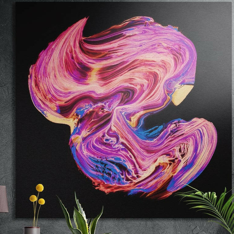 Pink and blue swirling ribbon brushed aluminum wall art on a dark concrete wall above potted plants and yellow flowers