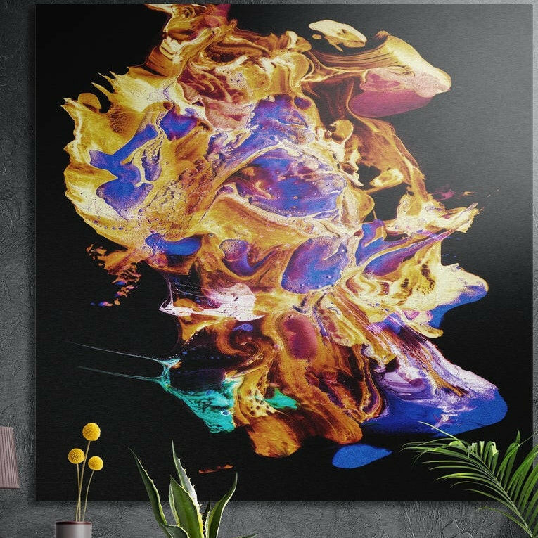 Gold and blue molten burst brushed aluminum wall art on a dark concrete wall above potted plants and yellow flowers