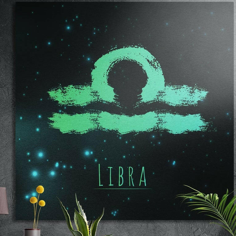 Libra zodiac sign in teal brushstrokes brushed aluminum wall art on a gray concrete wall above plants