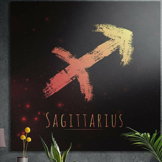 Sagittarius zodiac sign in coral gold brushstrokes brushed aluminum wall art on a gray concrete wall above plants