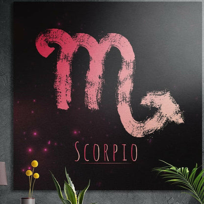 Scorpio zodiac sign in coral red brushstrokes brushed aluminum wall art on a gray concrete wall above plants