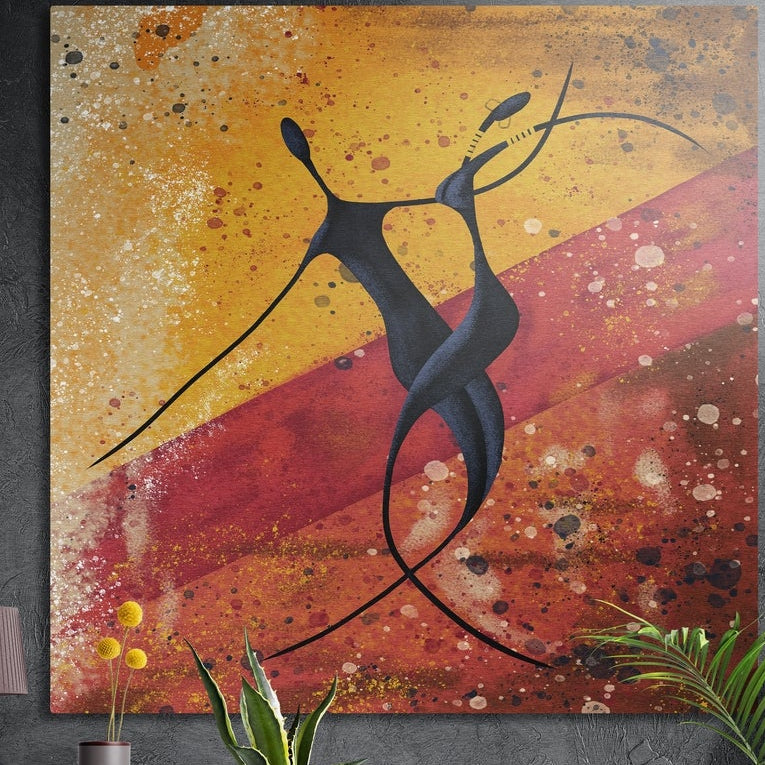 Two dancing figures on ochre and red brushed aluminum wall art on a dark concrete wall above potted plants and yellow flowers