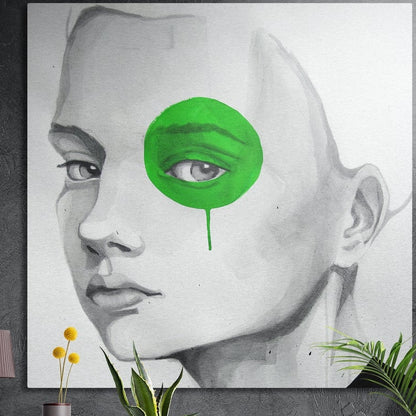 Gray sketch of a woman's face with one eye in a bright green blot, square brushed aluminum wall art on a dark wall