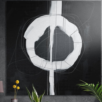 Black and white abstract ring brushed aluminum wall art on a dark wall above yellow flowers and plants