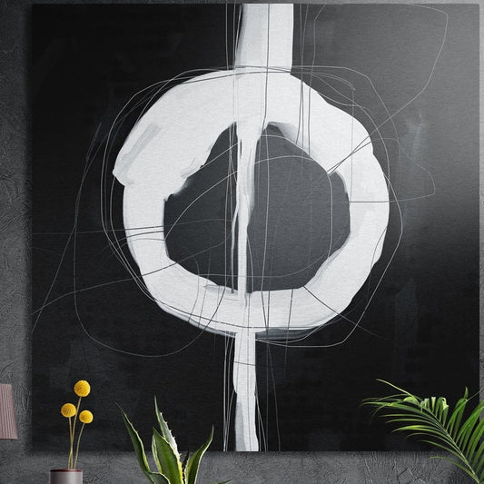 Black and white abstract ring brushed aluminum wall art on a dark wall above yellow flowers and plants