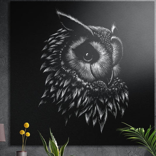 White line owl portrait on black, square brushed aluminum wall art on a gray wall behind plant leaves