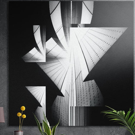 Black and white abstract architecture brushed aluminum wall art on a dark wall above yellow flowers and plants