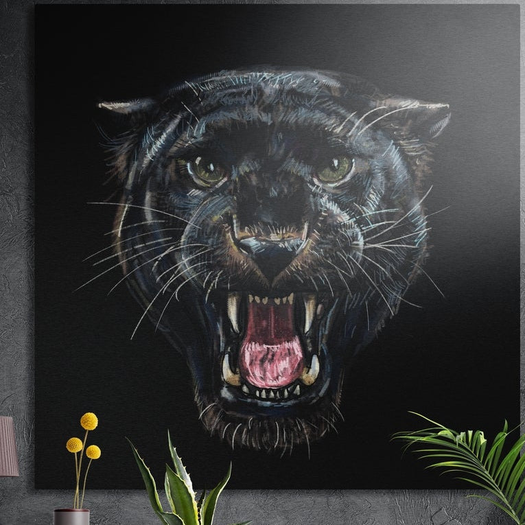 Snarling black panther face brushed aluminum wall art on a gray concrete wall above plants