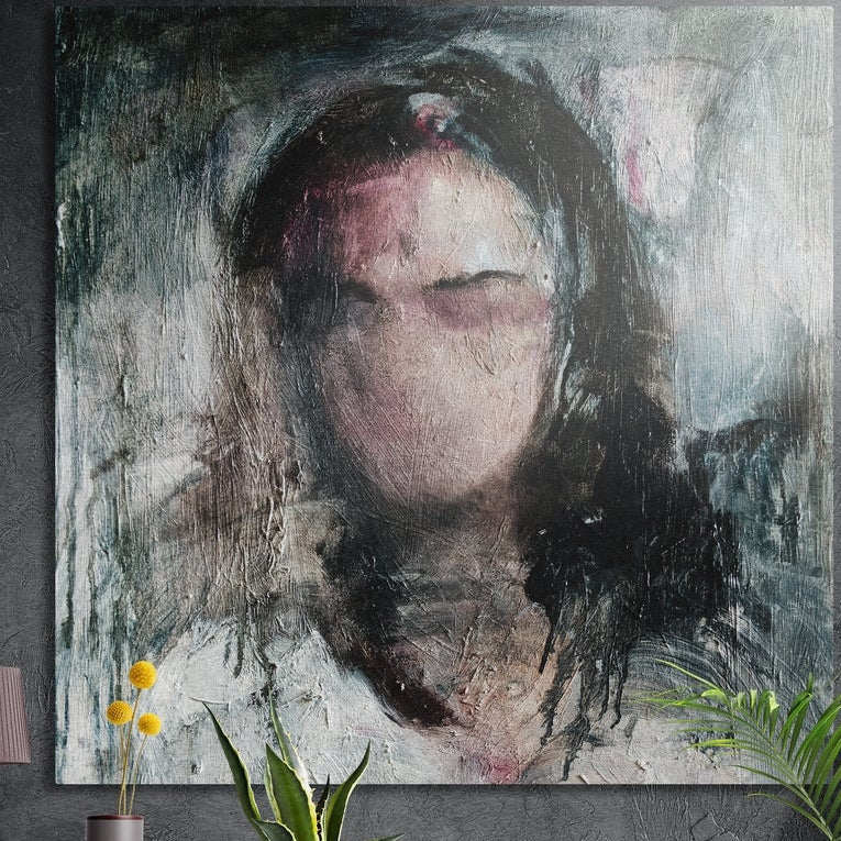 Expressive portrait of a woman with closed eyes, brushed aluminum wall art on a dark concrete wall above yellow flowers
