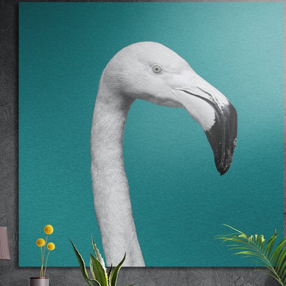 White flamingo head and curved neck on teal brushed aluminum wall art on a gray concrete wall above plants
