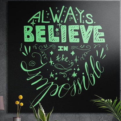 Always believe mint green hand lettering brushed aluminum wall art on a dark textured wall above potted plants