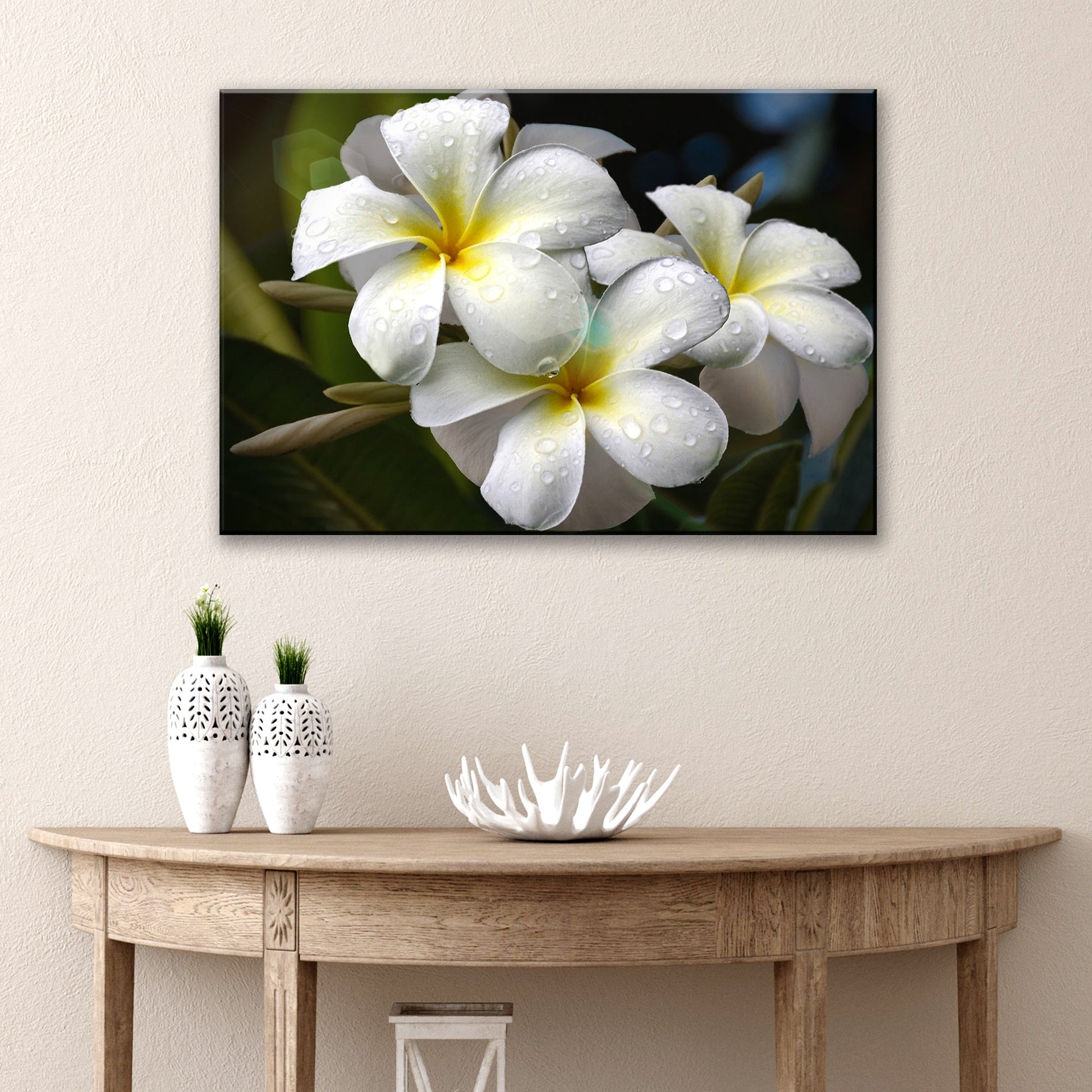 White frangipani flowers with yellow centers and green leaves canvas wall art