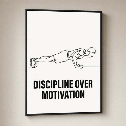 A framed minimalist fitness poster on a light beige wall. The poster features a black line drawing of a person in a plank position with the bold text 'DISCIPLINE OVER MOTIVATION' underneath, enclosed in a thin black frame.