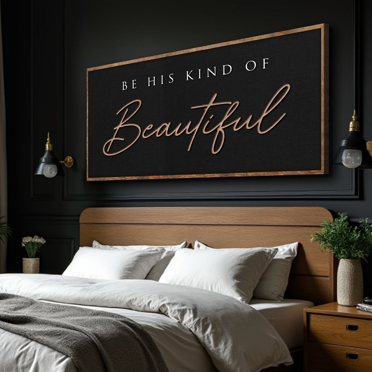 Black canvas sign with tan script reading Be His Kind of Beautiful, hung above a bed on a dark paneled wall