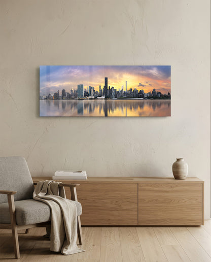 New York sunset skyline panoramic glass wall art above a light wood sideboard and beige armchair