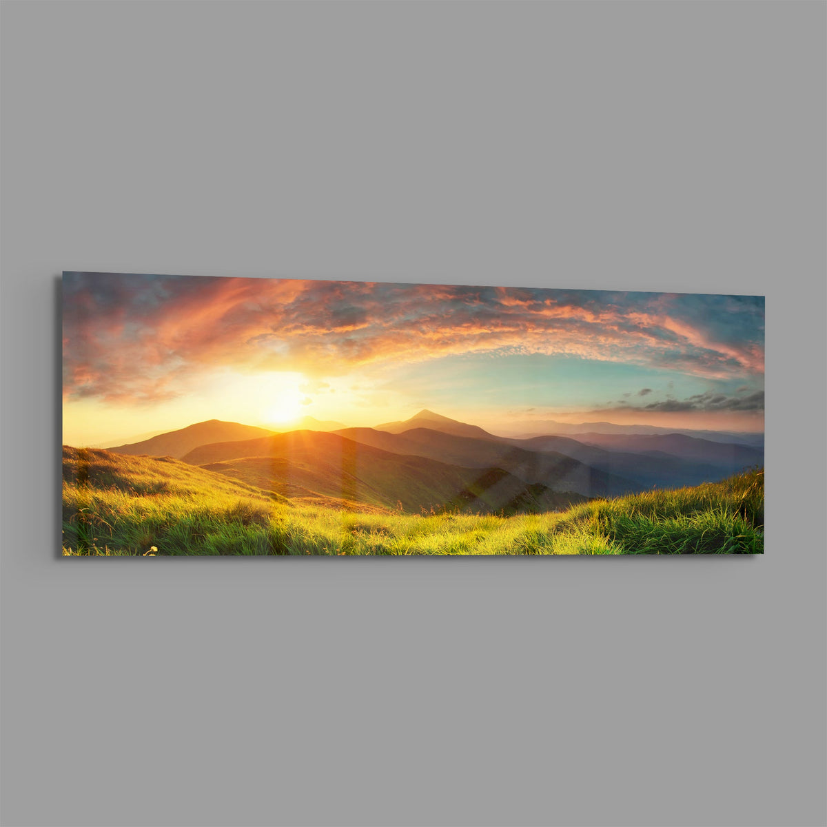 Golden sunset green hills panoramic glass wall art on a plain gray wall